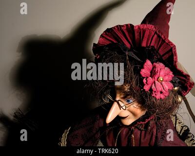 Puppet of a witch casting shadow on wall. Stock Photo