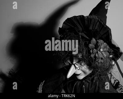 Puppet of a witch casting shadow on wall. Stock Photo