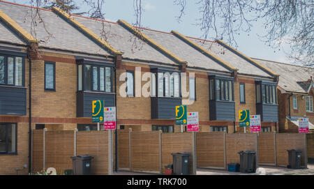 Foxtons and Barnard Marcus estate agents for sale boards outside a small development of new terraced mews houses, in Chiswick, London, England, UK. Stock Photo