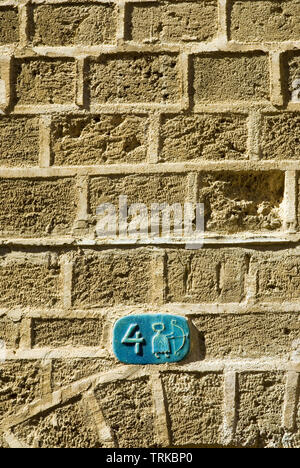 Ceramic door number plate with Sagittarius  symbol on a stone wall in Jafo, Israel Stock Photo