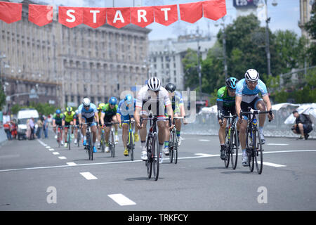 Group of cyclists crossing the start line. Cycle race among amateurs devoted to Day of Kiev. May 25, 2019. Kiev, Ukraine Stock Photo