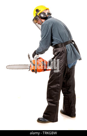 Man in safety gear demonstrating how to hold a chainsaw safely Stock Photo