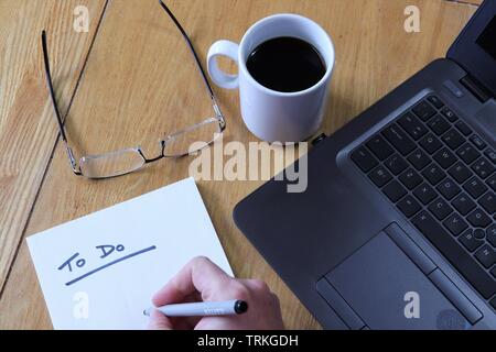 Flat lay of desk, with to do list, glasses, coffee and laptop Stock Photo