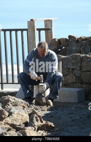 Workman rebuilding a wall on the island of Lanzarote in the islands of Canary Islands, Spain, Europe EU 2018 Stock Photo