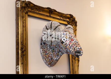 Rams head in frame made from fabric centred in frame hanging on wall. Stock Photo