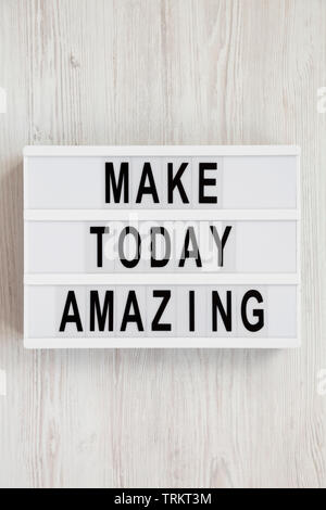 'Make today amazing' words on a modern board on a white wooden surface. From above, overhead, flat lay, top view. Close-up. Stock Photo
