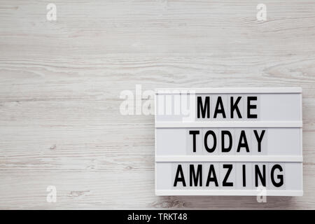 'Make today amazing' words on a modern board on a white wooden background. From above, overhead, flat lay, top view. Copy space. Stock Photo