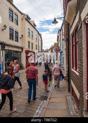 Tourists shopping on Church Street in Whitby North Yorkshire a traditional sea side town popular with tourists and holiday makers Stock Photo