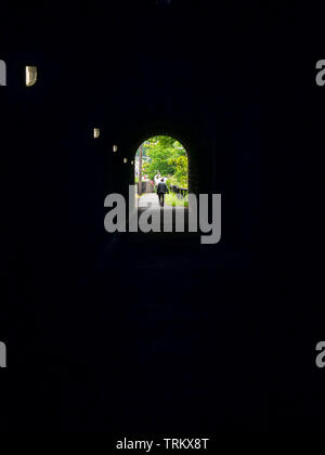 Lone figure of man walking away down a dark tunnel at Grosmont North Yorkshire Stock Photo