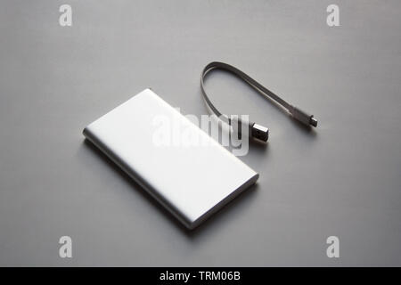 Portable aluminum power bank with USB cable isolated on white background Stock Photo