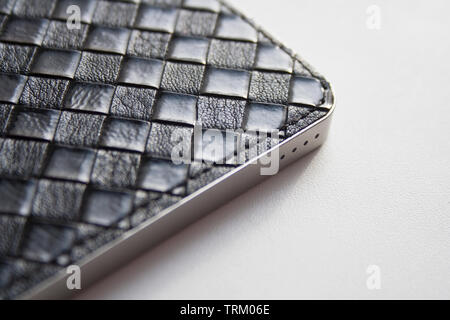 Black leather power bank case detail on white background close-up Stock Photo