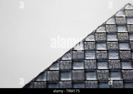 Black leather power bank case detail with tiles pattern isolated on white background close-up Stock Photo