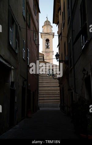 Narrow alley with a view of the saint mary in fontibus church. Albenga, Liguria, Italy. Stock Photo