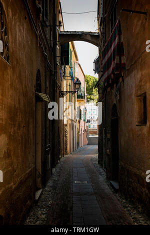 Picturesque narrow alley with a cloth hanging dry, in Albenga, Liguria, italy. Stock Photo