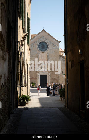 Narrow alley with a view of the St Michael cathedral. Albenga, Liguria, Italy. Stock Photo