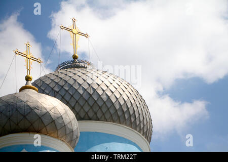 Close-up of the two domes of the church with golden crosses against the blue sky with clouds, soft focus, copyspace Stock Photo