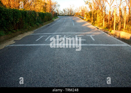 Background of the road with the inscription ticket at sunrise and the first rays, trees and grass on the roadside, the concept of travel and moving fo Stock Photo