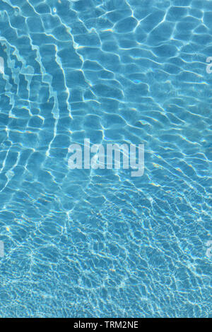 Small ripples on the surface of a swimming pool dissipating Stock Photo
