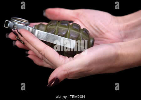 hand grenade in girl hand on black background Stock Photo