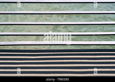 The close-up of the cross struts of a bridge railing casting symmetrical shadows. Stock Photo