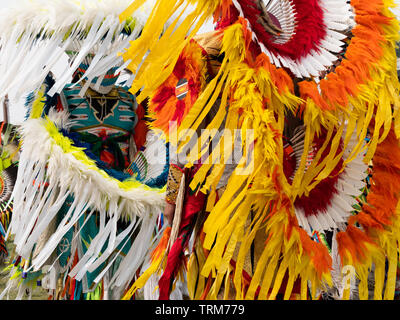 Close up of two Native American men fancy dancers wearing feather and quill headdresses and bustles at a pow wow in Montana. Stock Photo