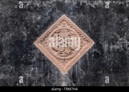 Black tiles floor with brown stone carving of dragons in chinese park Stock Photo