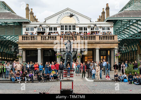 Street performer entertaining a crowd in Covent Garden, London, England. Stock Photo