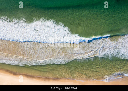 Waves beach onto the beach an Dudley Beach - Newcastle NSW Australia. Aerial view straight down.