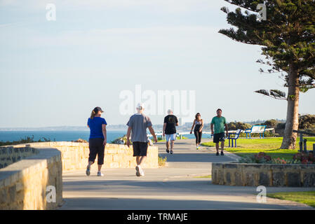 Early morning walkers on the beachside path at Cottesloe, with Scarborough Beach in the background. Stock Photo