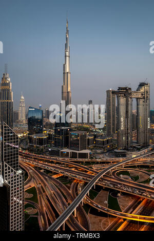 The Burj Khalifa and downtown Dubai including a massive highway interchange at sunset Stock Photo
