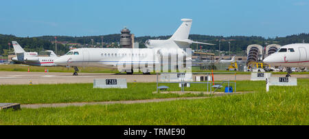 Kloten, Switzerland - June 8, 2019: airplanes at Zurich Airport,  a Dassault Falcon 7X in the foreground. The Dassault Falcon 7X is a large-cabin busi Stock Photo