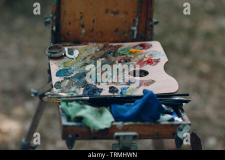 Palette with oil paints on the easel Stock Photo