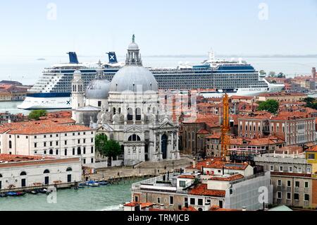 The rooftops of Venice dominated by a large cruise liner entering the port along the Giudecca canal, Italy Europe Stock Photo