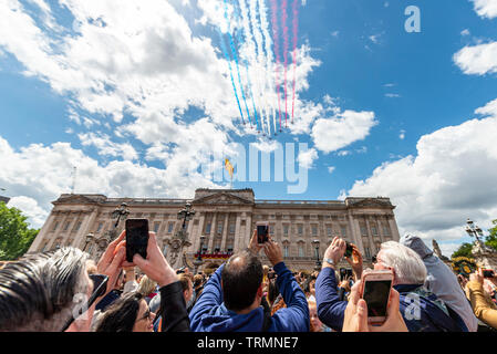 The Royal Air Force Red Arrows passing over Buckingham Palace for the Queen's Birthday Flypast 2019 with crowds. London, UK Stock Photo