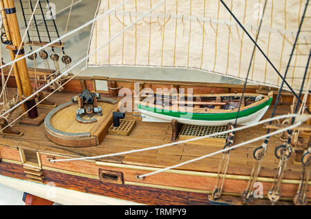 Reduced ship model. Fragment of the deck of a pirate sailing ship with a cannon on a rotating gun carriage and a lifeboat Stock Photo