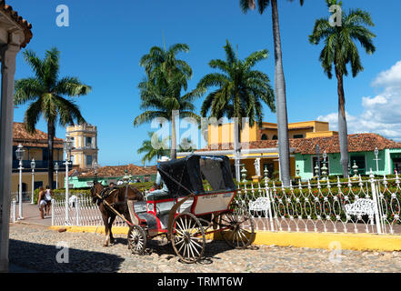Horse carriage driving through Plaza Mayor, the main central square, of tthe UNESCO town of Trinidad, Sancti Spiritus Province, Cuba,Caribbean Stock Photo