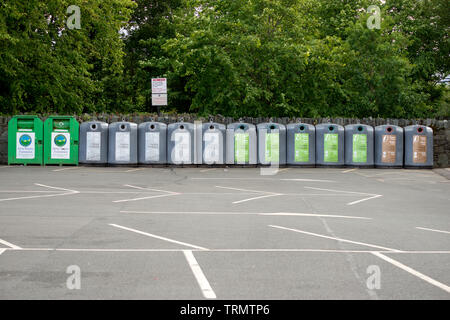 Row of recycling containers bins in empty car park Killarney, County Kerry, Ireland Stock Photo