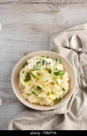 A plate of mashed potatoes poured with melted butter and seasoned with greens Stock Photo