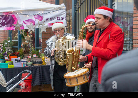 Vancouver, BC, Canada - 11/25/18: Jazz musicians playing saxophone, drum, and trumpet at Yaletown CandyTown even in Vancouver, B.C., in red suits and Stock Photo
