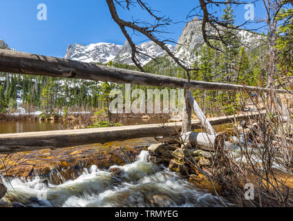 Footbridge over the Fern Lake Outlet with Thatchtop and Gabletop Mountains behind in Rocky Mountain National Park, Estes Park, Colorado. Stock Photo