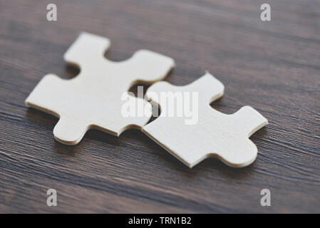 jigsaw puzzle on wooden background top view / Two jigsaw piece connecting business solutions success and strategy concept Stock Photo