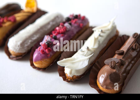 Set of several eclairs with various fillings and design isolate on a white background, the concept of French cuisine, copyspace Stock Photo