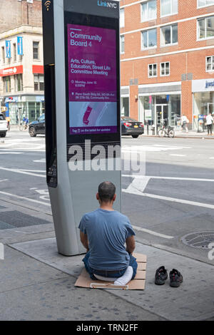 A Muslim food vendor takes a work break to say his daily prayers. On Eighth Ave in the Chelsea section of Manhattan, New York City. Stock Photo