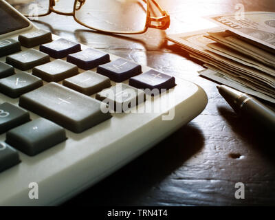 Wealth management and personal finances. Calculator, stack of money and pen. Stock Photo