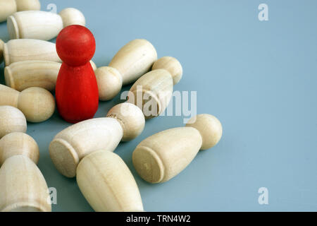 Success in business competition concept. Red figurine and wooden ones. Stock Photo