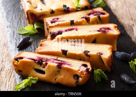 Summer sponge cake with honeysuckle and mint on the board closeup on a wooden table. horizontal Stock Photo