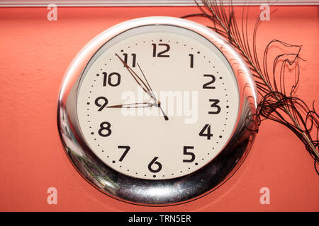Antique Simple design and decoration classic clock hang isolated on red wall background. Time concept. Stock Photo