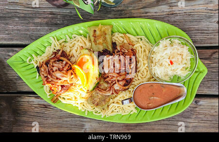 Swabian spaetzle, maultaschen with fried onion rings and gray sauce, top view Stock Photo