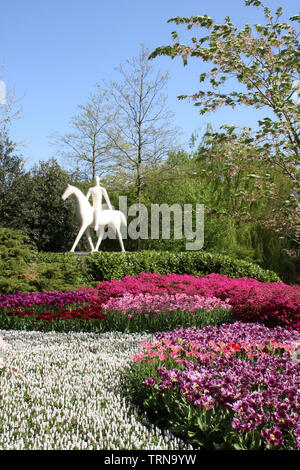 White sculpture of a man on horseback in floral display in Keukenhof Gardens near Lisse in South Holland, Netherlands on a sunny spring day in 2019. Stock Photo