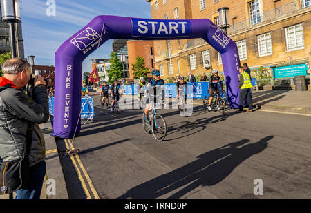 June 2019, Norwich 100 bike ride: Cyclists taking part in the Norwich cycle ride leaving the starting gate to embark on their one hundred mile tour ar Stock Photo